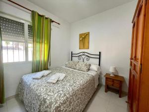 奇克拉纳－德拉弗龙特拉Apartamento Marinero del Sur的一间卧室配有一张床,上面有两条毛巾