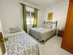 奇克拉纳－德拉弗龙特拉Apartamento Marinero del Sur的一间卧室设有两张床和窗户。