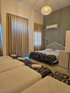 提比里亚Atara Hotel的一间设有四张床和吊灯的客房