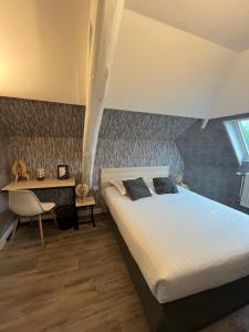 特鲁瓦托耶酒店的一间卧室配有一张床、一张桌子和一张书桌