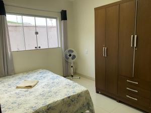 帕图斯迪米纳斯Apartamento terreo com quintal individual的一间卧室配有一张床、一个梳妆台和一扇窗户。