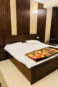 奈尼塔尔RajMahal Nainital的卧室设有一张大床,卧室设有木墙