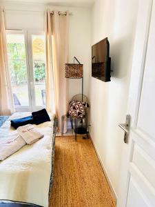 圣特罗佩Chez Garance à la Bouillabaisse的一间卧室设有一张床、一台电视和一个窗口。