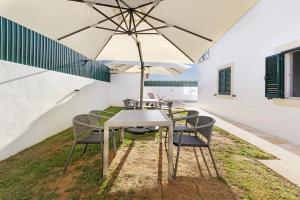 卡斯卡伊斯Mansão Domiga Adão的庭院内桌椅和遮阳伞
