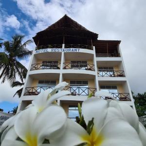 肯杜瓦Villa Vanilla Kendwa的前方有白色花卉的酒店度假村