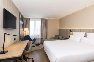 奥伯丁NH酒店慕尼黑机场店的酒店客房设有一张大床和一张书桌。