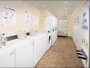 普兰菲尔德Extended Stay America Select Suites - Indianapolis - Plainfield的洗衣房配有白色洗衣机和烘干机
