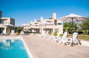 拉里奥哈Casa Adela - Cabañas Resort的一组椅子和遮阳伞,位于游泳池旁