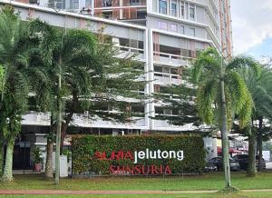 莎阿南SGA SuriaJelutong的一座楼前有棕榈树的酒店