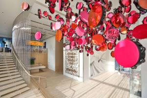 达拉斯HALL Arts Hotel Dallas, Curio Collection by Hilton的一间设有吊灯的房间,配有粉红色和橙色气球