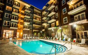 夏洛特Premium Apartments and Studios at Midtown 205 in Charlotte的一座游泳池,在晚上在建筑物前
