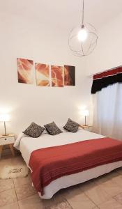 布宜诺斯艾利斯Boedo Tango的卧室配有一张墙上三幅照片的床