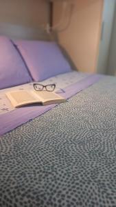 马焦内Monolocale Azzurra的睡床上一副眼镜