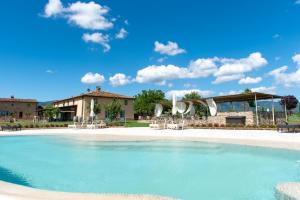 斯卡尔佩里亚Tenuta Le Tre Virtù的一座带游泳池的度假村,位于一座建筑前