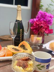 沙帕达-杜斯吉马朗伊斯Bangalô Miraflores的一张桌子,上面放着一瓶香槟和一些水果