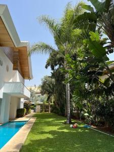 布兹尼盖Belle Villa à Bouznika plage - Golf Bouzbay的房屋旁的庭院,带游泳池