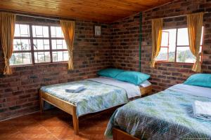 杜伊塔马Cabaña Campestre La Esperanza的带2扇窗户的客房内的2张床