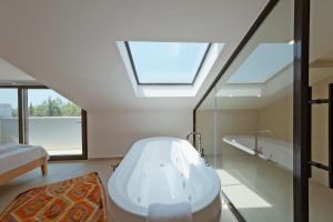 费特希耶Villa Neo with Jakuzi,indoor pool,sauna and floor heating的带浴缸和天窗的浴室