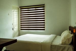 卡尔佩特塔ADONAY INN RESIDENCY的卧室配有白色的床和窗户。