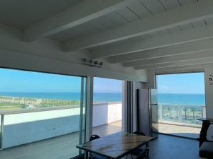 巴列塔Attico - Il Panorama的客厅配有桌子,享有海景