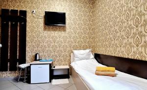 基辅Lisova - Лісова готельня і сауна的一间卧室配有一张床、一张书桌和一台电视。