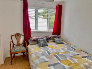 曼彻斯特Entire 3 Bedroom House Near City Centre + FREE Parking的卧室配有床、椅子和窗户。