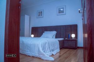 BueaCloud Hill的卧室配有一张白色大床和木制床头板