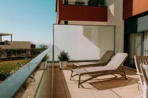 福恩吉罗拉Little Dream - Luxury Beach Retreat的阳台配有椅子和桌子