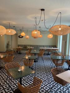 雷根斯堡Hotel Das Regensburg的餐厅设有桌椅和吊灯。