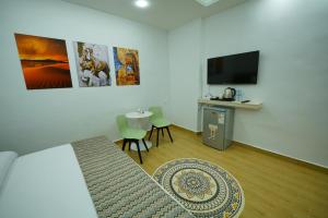 瓦迪穆萨simple street apartment的客厅配有电视和桌椅
