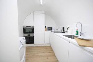 伦敦Lovely flat in Baker street的白色的厨房配有白色橱柜和水槽