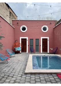 瓜达拉哈拉Quinta La Perla的一座红色的建筑,前面设有一个游泳池