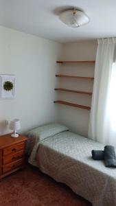 林孔-德拉维多利亚APARTAMENTO PLAYA AZUL的一间卧室配有一张床、一个梳妆台和一扇窗户。