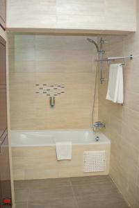 黑角Mayombe Arena Hotel的设有带浴缸和淋浴的浴室。