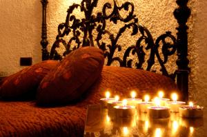 鲁伊德拉艾奥巴曼捷乡村酒店的一组灯光烛光坐在床上