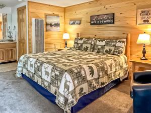 埃斯蒂斯帕克Nicky's Resort的卧室配有一张床铺,位于带木墙的房间内