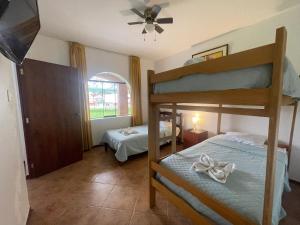 SunampeHospedaje El Cascabel的一间卧室设有两张双层床和吊扇