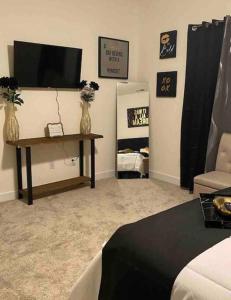 夏洛特Luxurious 3 Story Townhome的客厅配有电视和鲜花桌