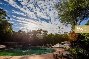 伊瓜苏港塞尔瓦伊维酒店的享有天空中树木和云层的游泳池景色