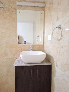 门格洛尔Suvarna Grande Homes的一间带水槽和镜子的浴室