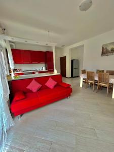 帕代诺杜尼亚诺Grazioso Bilocale alle Porte di Milano的一间带红色沙发的客厅和一间厨房