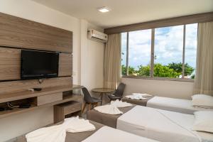 福塔莱萨普拉亚马尔酒店的一间酒店客房,设有三张床和一台平面电视
