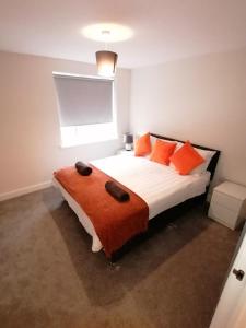 斯托尼斯特拉特福Apollo Avenue Apartment的一间卧室配有带橙色枕头的床和窗户。