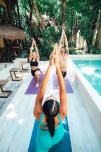 普拉亚卡门Terasu Riviera Maya Hotel & Spa, en Xcaret的一群在游泳池边做瑜伽的女性