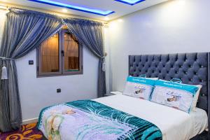 达赫拉ADAM APPARTEMENTS的一间卧室配有一张蓝色天花板的床