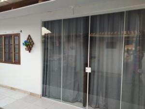 南圣弗朗西斯科Kitnet Praia de Ubatuba的玻璃门滑动门,带灰色窗帘的房间