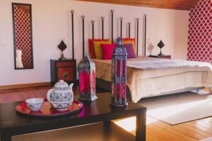 TravancinhaCasas de Campo Villa D'Almeida的一间卧室,配有一张带花瓶的桌子