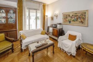 雅典Vintage apartment KOLONAKI的客厅配有沙发、椅子和桌子