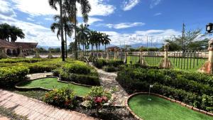比亚维森西奥Tequendama Hotel Campestre Villavicencio的棕榈树花园内的迷你高尔夫球场