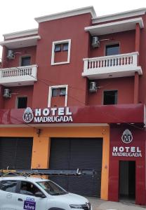 圣保罗Hotel Madrugada的一辆红色的酒店,前面有一辆汽车